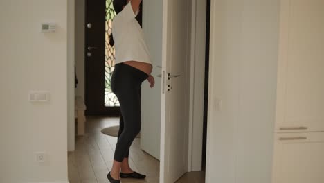 a beautiful pregnant woman tidying her home, engaged in household chores. the scene captures domestic life, maternity, and the balance of routine and preparation during pregnancy