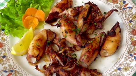 grilled and fried seafood on a traditional mediterranean plate garnished with summer vegetables and fruits - greece, croatia, italy, montenegro, squid.