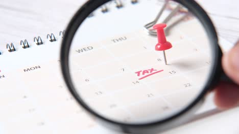 concepto de día de impuesto con la celebración de lupa y palabra de impuesto en la fecha calendario