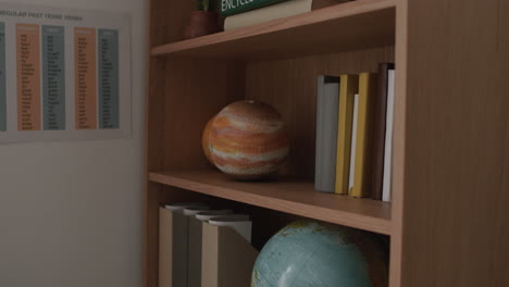 Organized Bookshelf with Globes and Documents