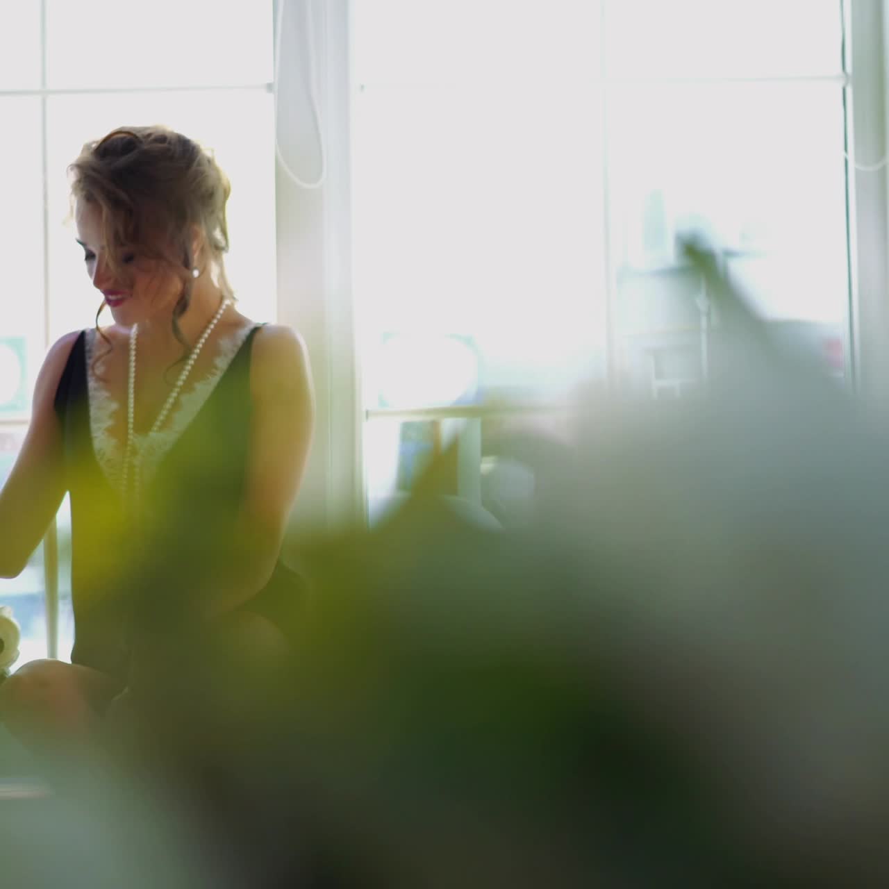Playful seductive young woman near window