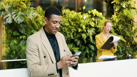 Hombre-Afroamericano-Usando-Un-Teléfono-Inteligente-En-Un-Hotel