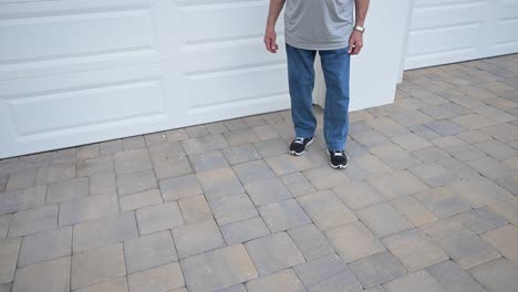 man stands in front of his new garage door and gives a thumbs-up, approving of his maintenace