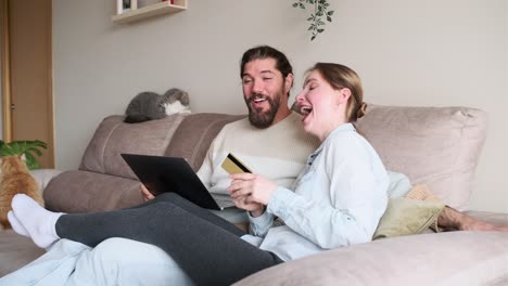 couple shopping online with tablet and credit card at home