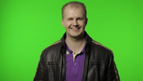 Rocker-man-saluting-with-hand-and-pretending-to-listen-order.-Guy-biker-on-chroma-key-background