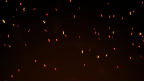 ardientes chispas rojas y calientes volando de una gran llama de fuego sobre un fondo negro.