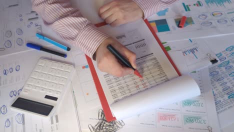 close-up of hands making notes on the financial report