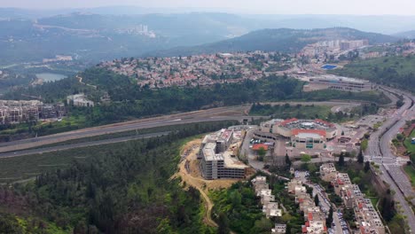 aerial view of a city built into hills with residential areas, roads, and ongoing construction