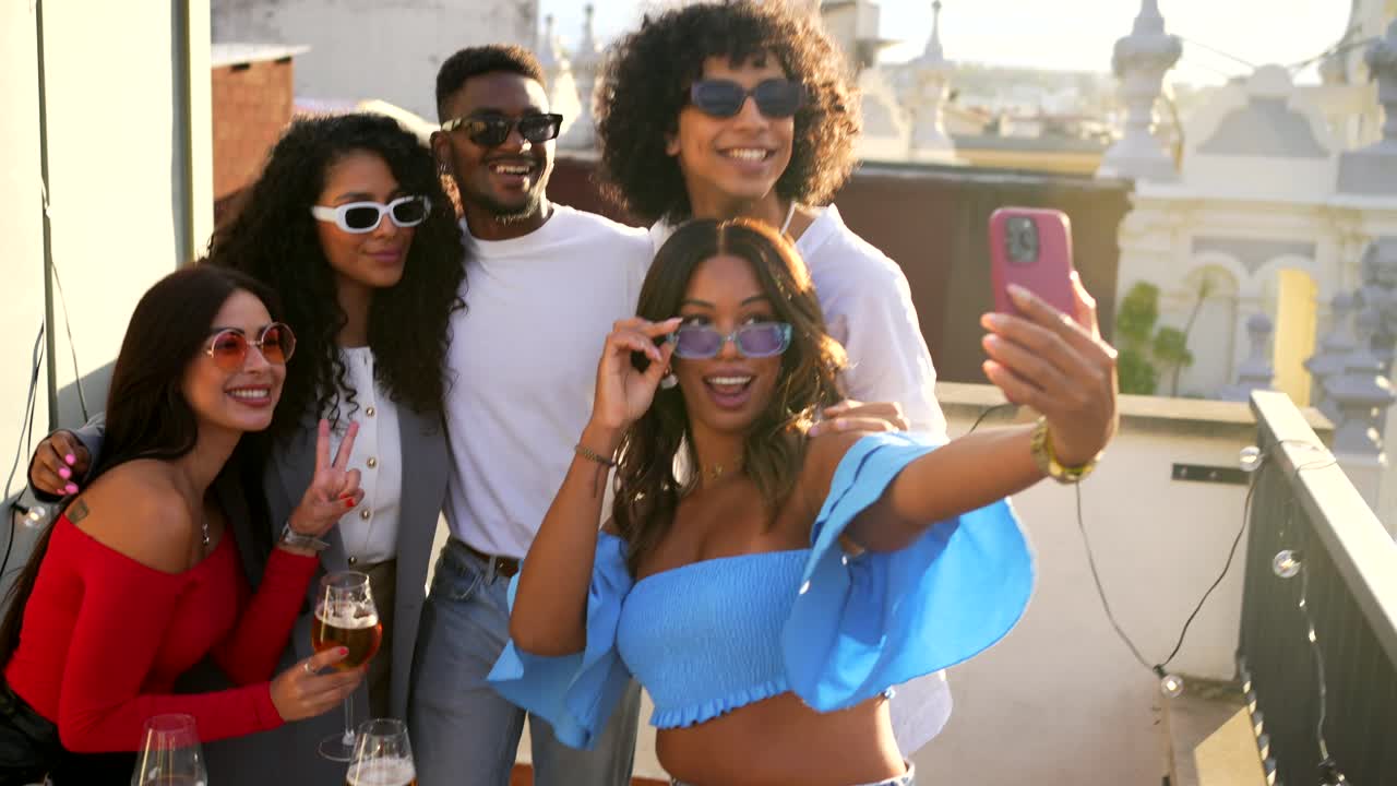 Friends enjoying a rooftop party taking selfies