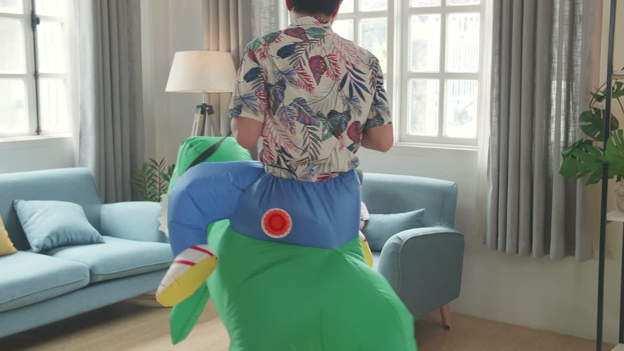 Asian Father Ride Dinosaur Toy While His Son Using Mobile Phone In Modern House Living Room, Happy Family