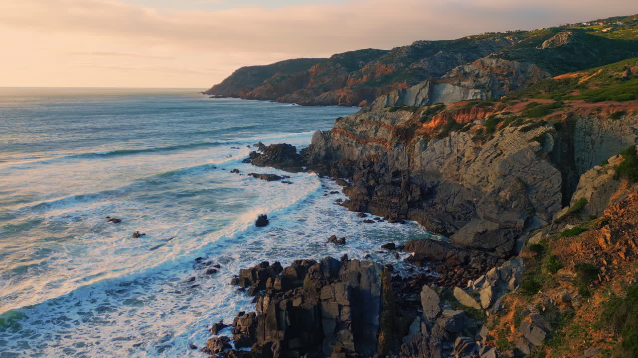 Aerial flying rocky seashore waves breaking coastline. Ocean splashing on cliffs
