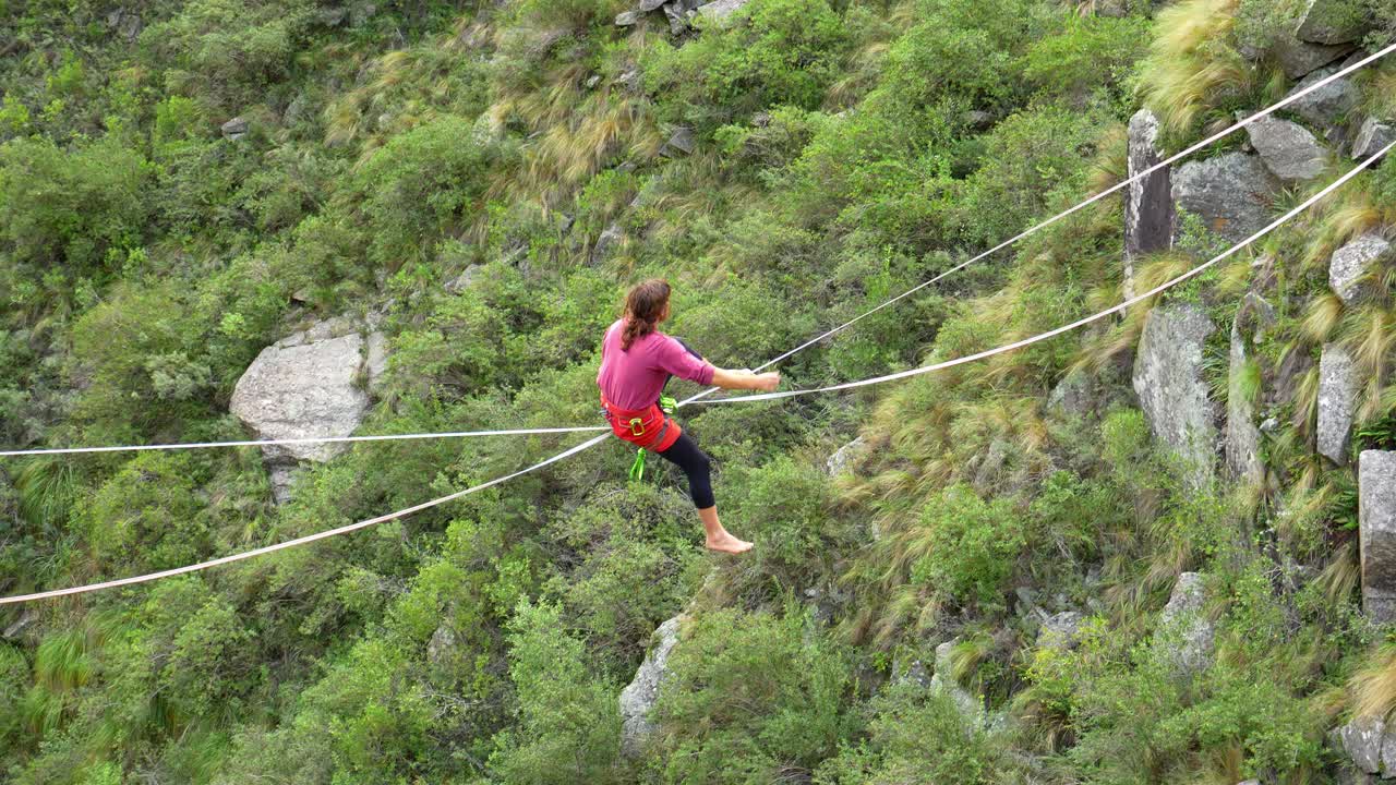 un hombre se levanta a lo largo de una eslinga estirada y luego cae