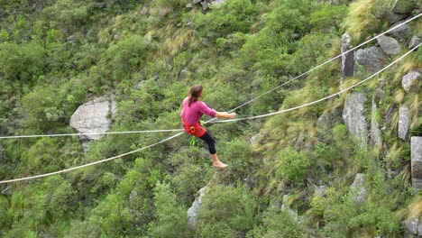 a man stands up along a stretched sling and then falls