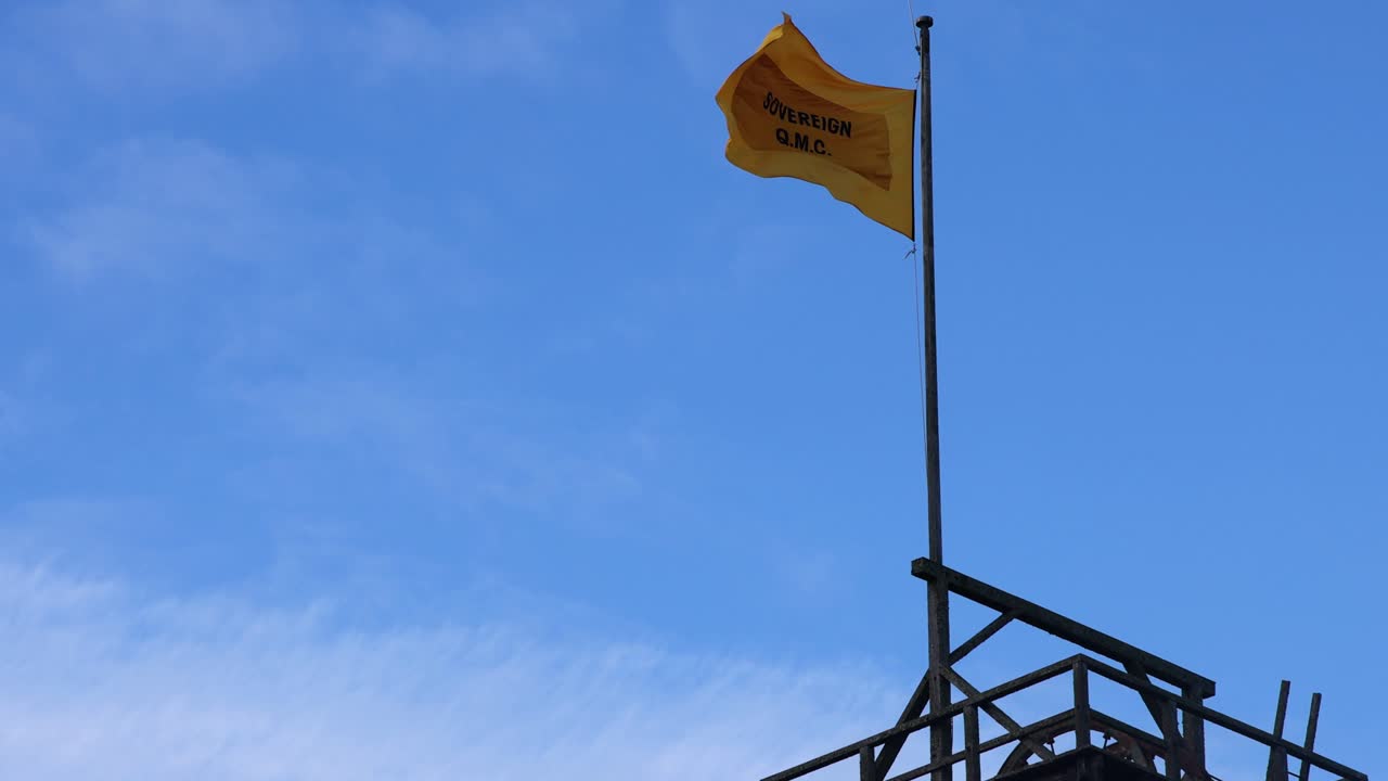bandera amarilla ondeando contra el cielo azul
