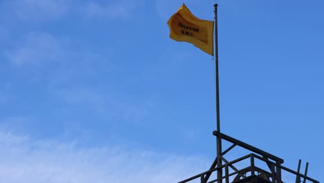 bandera amarilla ondeando contra el cielo azul