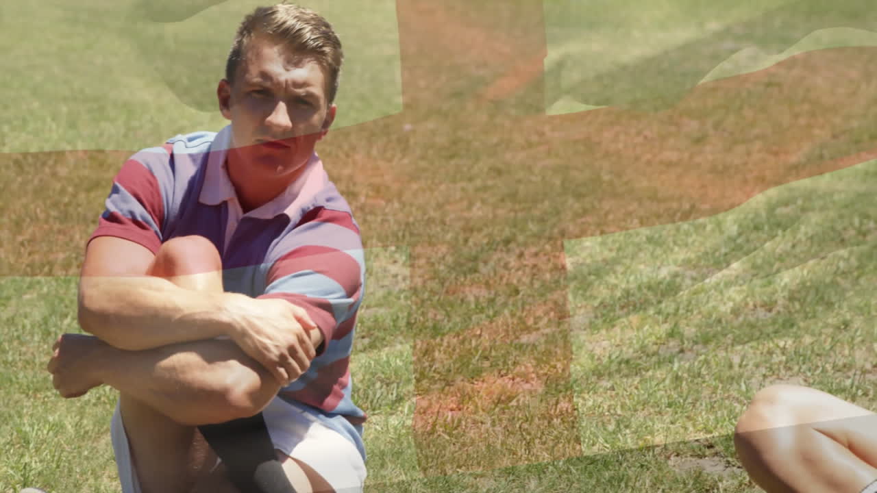 Sitting on grass with arms crossed, man thoughtfully watching animation in park