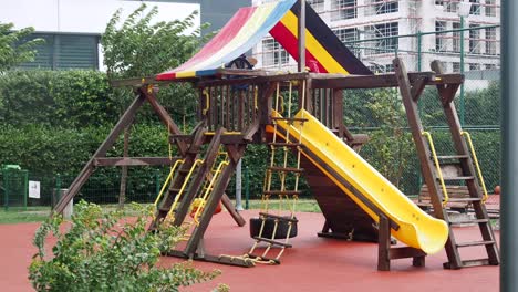 wooden playground with colorful slide and swing set