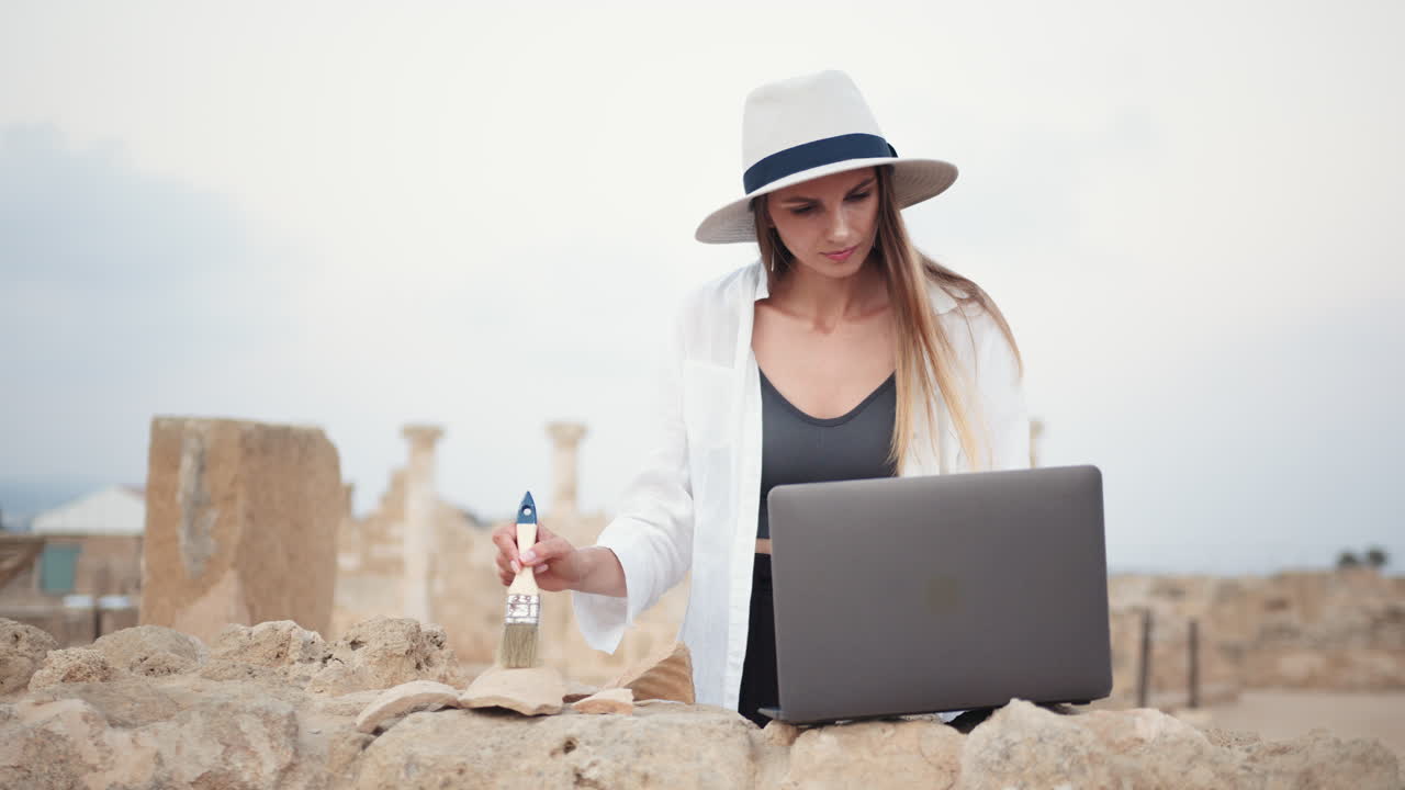 arqueólogo trabajando en un sitio antiguo con una computadora portátil
