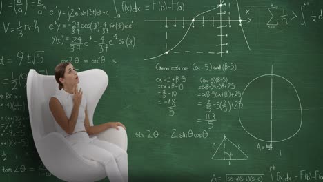 Woman-sitting-in-front-of-chalkboard-with-moving-calculations-on-it