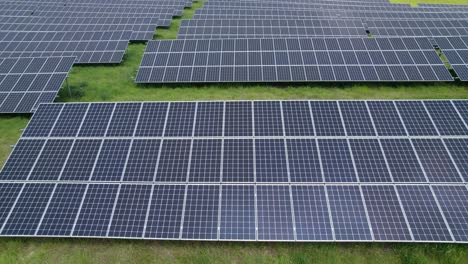 Aerial-trucking-close-shot-of-the-solar-panels-on-the-green-field