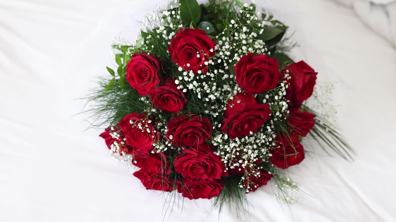 A beautiful bouquet of red roses and baby's breath on a white background