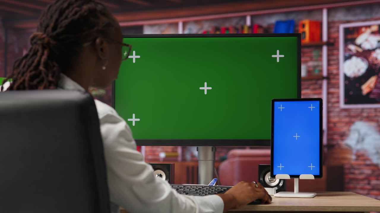 freelancer in ufficio a casa utilizzando pc a schermo verde e tablet mockup