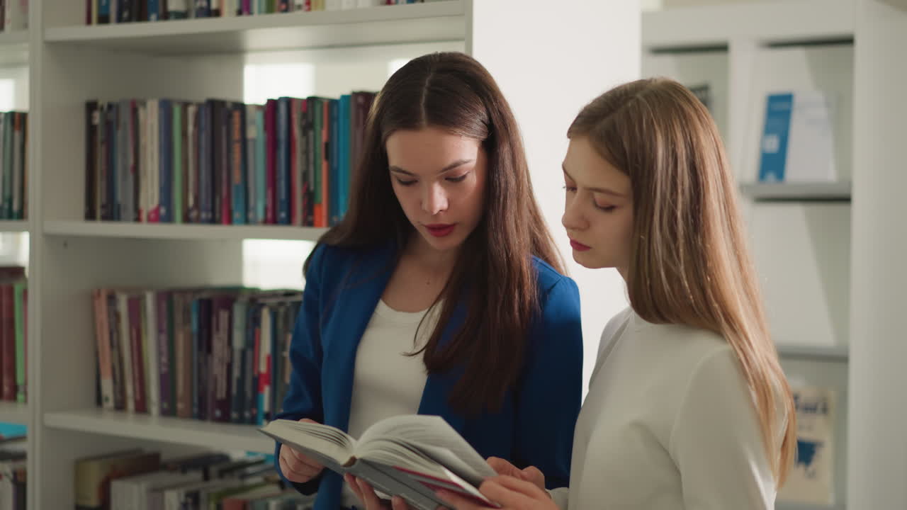 los estudiantes leen novelas juntos en la biblioteca. las mujeres jóvenes concentradas estudian literatura educativa en la tienda. los visitantes de la tienda aprenden artículos en el libro de texto.