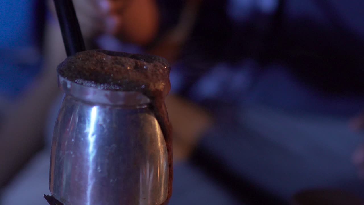 grupo de viajeros haciendo café en la naturaleza por la noche, diversión de caminatas y alojamiento en la naturaleza el café burbujea y se derrama de la olla cerca de la olla con el café
