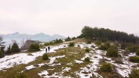 Athletes-running-in-the-mountains-in-winter-drone-shot