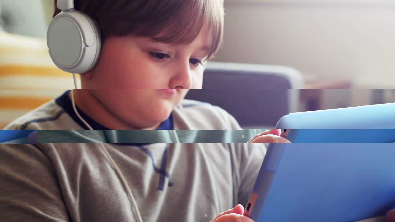 niño con auriculares usando tableta digital en la sala de estar 4k