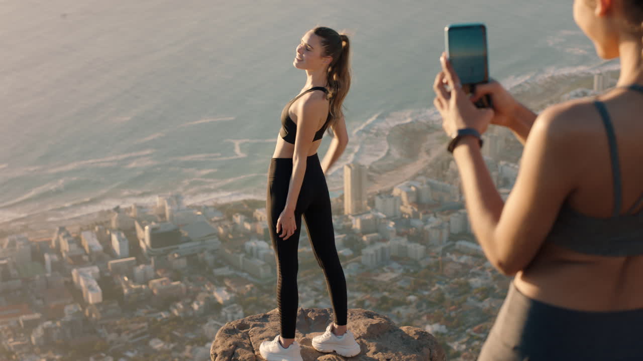 amigas tomando fotos en la cima de la montaña usando la cámara del teléfono inteligente hermosa mujer joven posando para un amigo con el teléfono móvil compartiendo la aventura de senderismo en las redes sociales