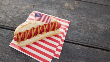 video of hot dog with mustard and ketchup with flag of usa on a wooden surface