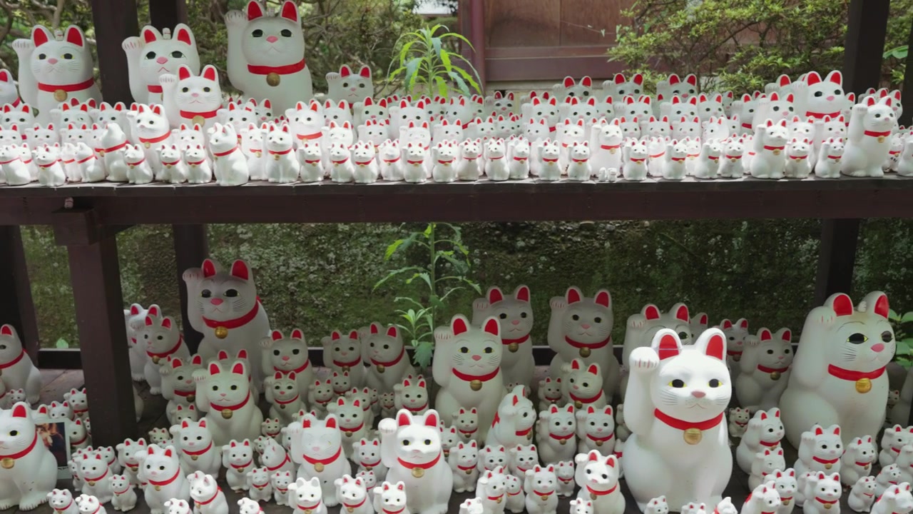 Innumerevoli famose statue di gatti portafortuna Maneki Neko esposte al Tempio Gotokuji, creando una scena accattivante che rappresenta fortuna, ricchezza e felicità nella tradizione giapponese