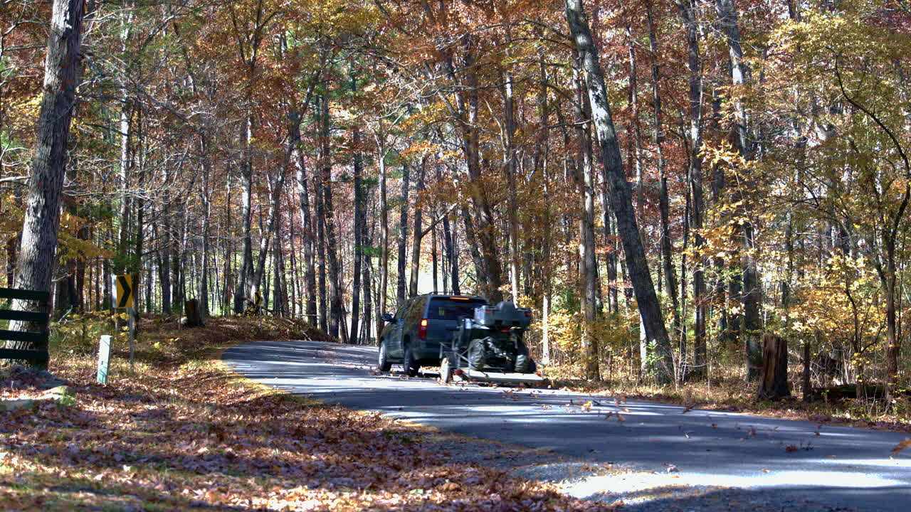 suv가 지나가는 가을의 시골 도로