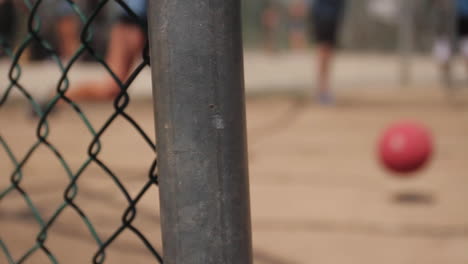 mujer patea kickball en el fondo de la valla