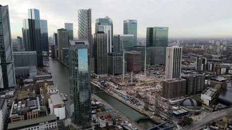 Panorámica-Aérea-Que-Muestra-Rascacielos-De-Lujo-De-Canary-Wharf-Con-El-Río-Támesis-En-Londres,-Reino-Unido