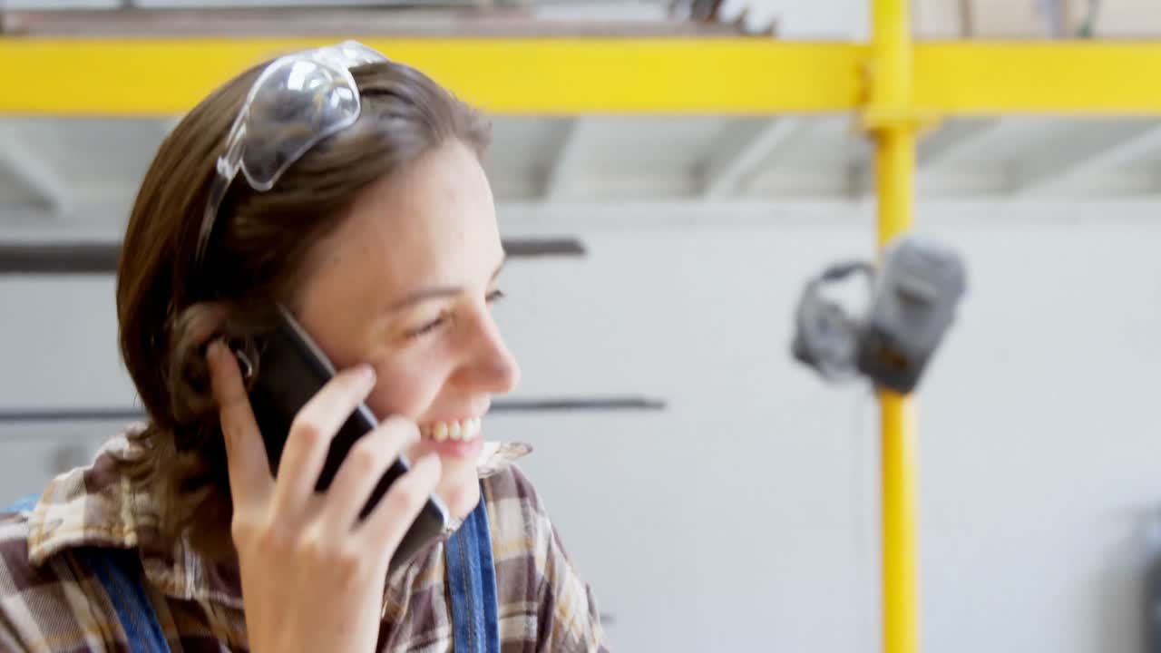 carpinteiro a falar ao telemóvel na oficina 4k