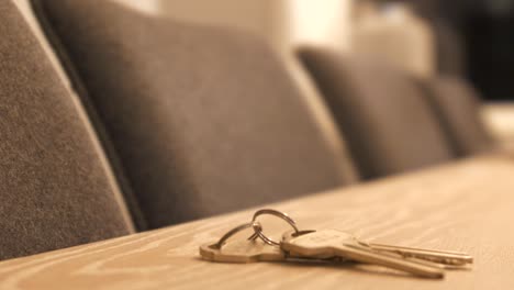 hand placing set of house keys on table, selling buying real estate concept