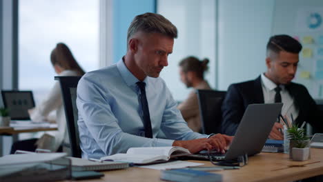 Handsome-businessman-taking-notes-on-notebook