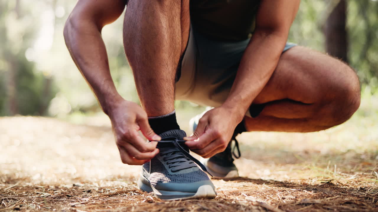 Primo piano di un uomo che allaccia i lacci delle scarpe da corsa all'aperto