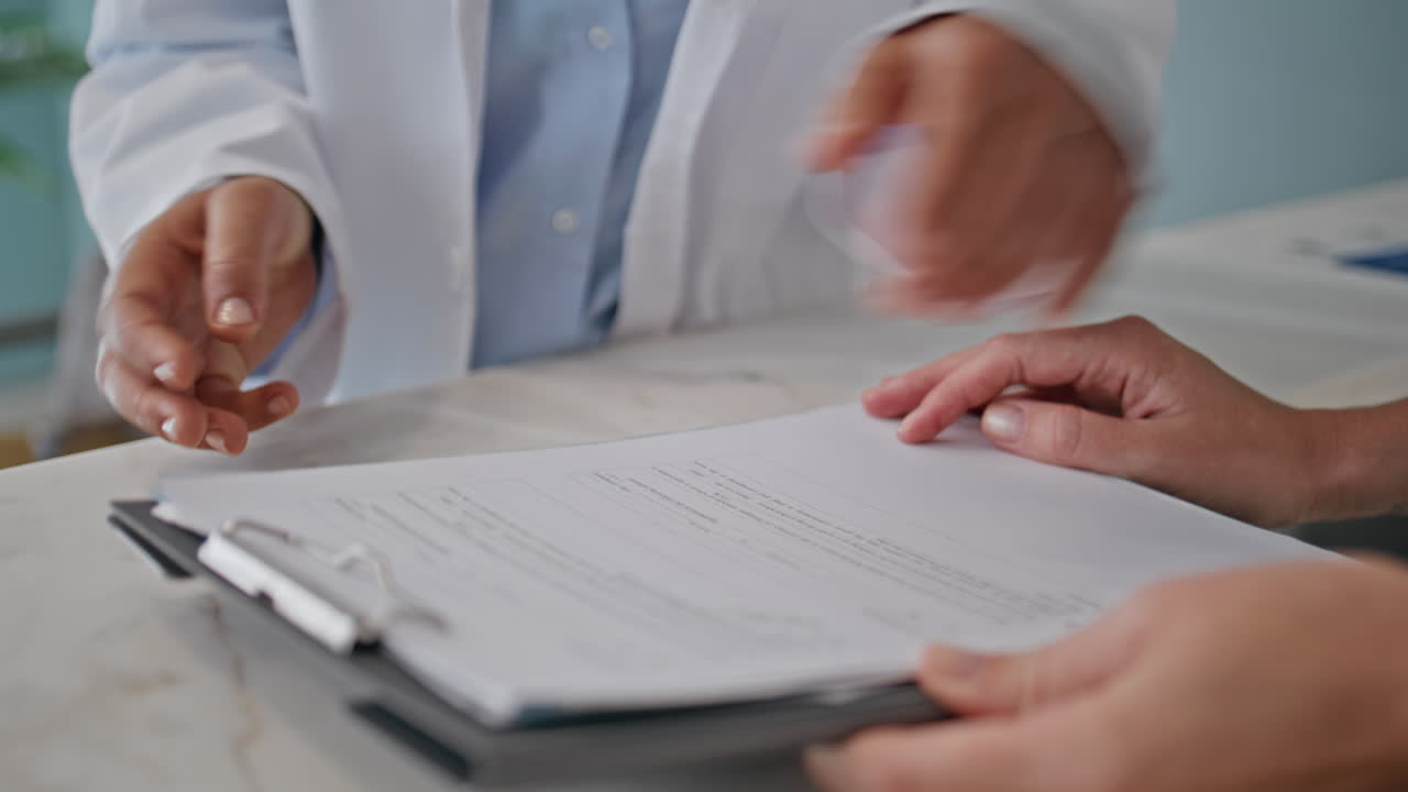Medic reviewing paperwork consultation with colleague in medical office closeup
