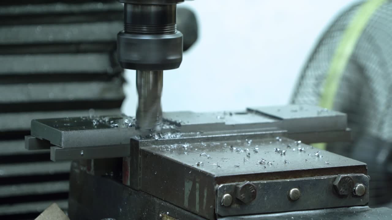 Metal fiber is rotating around big drill of steel metal lathe machine engine, technology manufacturer in operation process in industry manufacturing plant factory. Raw product equipment in warehouse.