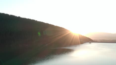 aerial shot, frumoasa dam romania with bright sunset and lens flare