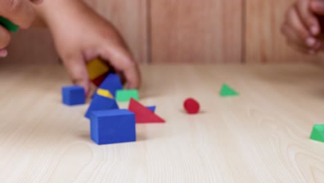 hands arranging colorful foam blocks on table