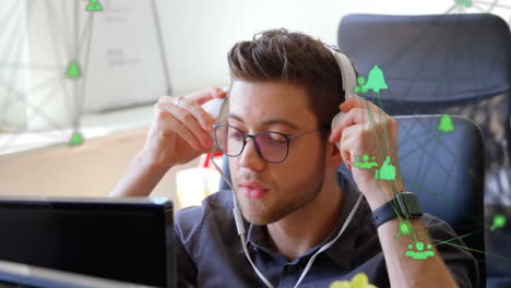 animation of network of connections with icons over caucasian man wearing headphones