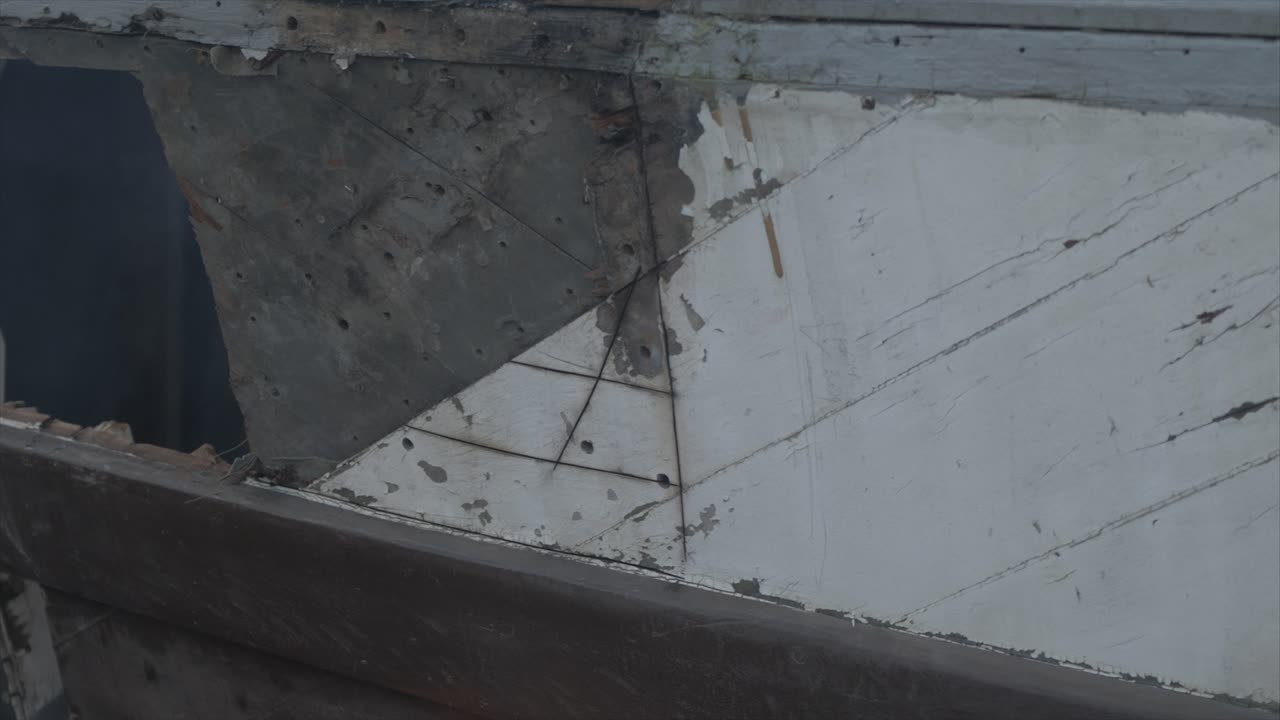 80년 된 나무 보트에 앵글 그라인더로 썩은 마호가니 판자 자르기