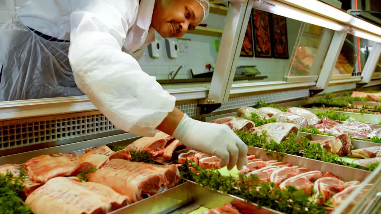 macellaio che organizza la carne nel frigorifero 4k