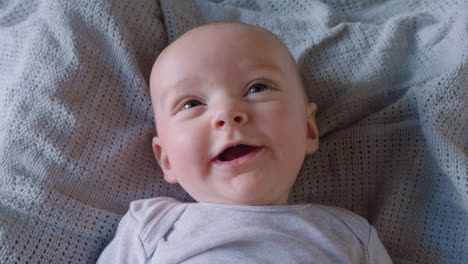 portrait beautiful baby looking curious infant lying on blanket