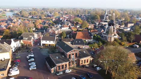 The-old-station-house-of-Winsum,-Netherlands-from-above-with-a-windmill-in-the-background