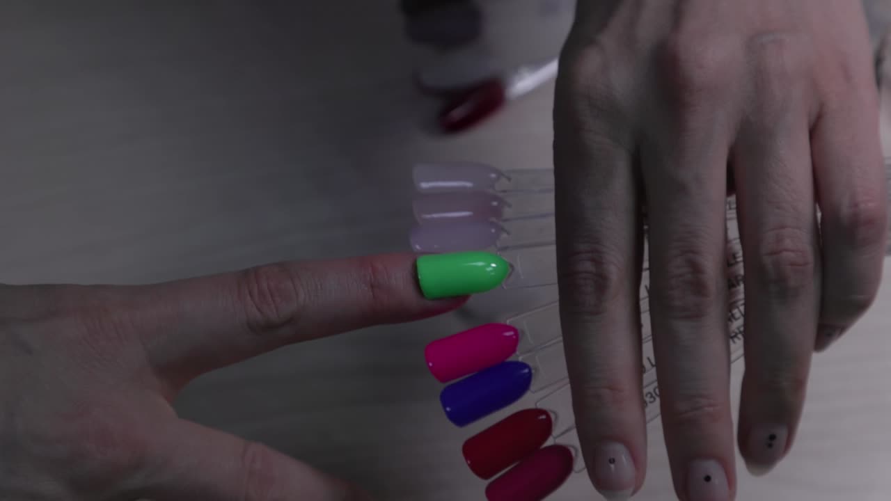 mujer eligiendo el color del esmalte de uñas para la manicura. selección del color de la laca de uñas. mujer eligiando el color de las uñas de tester.